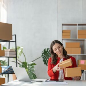 girl working with laptop Online e-commerce at her store. A young woman prepares a parcel box to